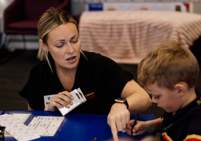 Speech pathologist conducting an early years developmental screening with a young child in a learning environment.