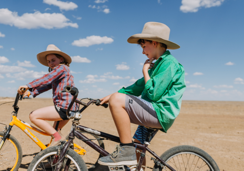 Two children riding bikes and enjoying time outside after school.