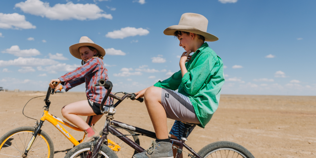 Two children riding bikes and enjoying time outside after school.